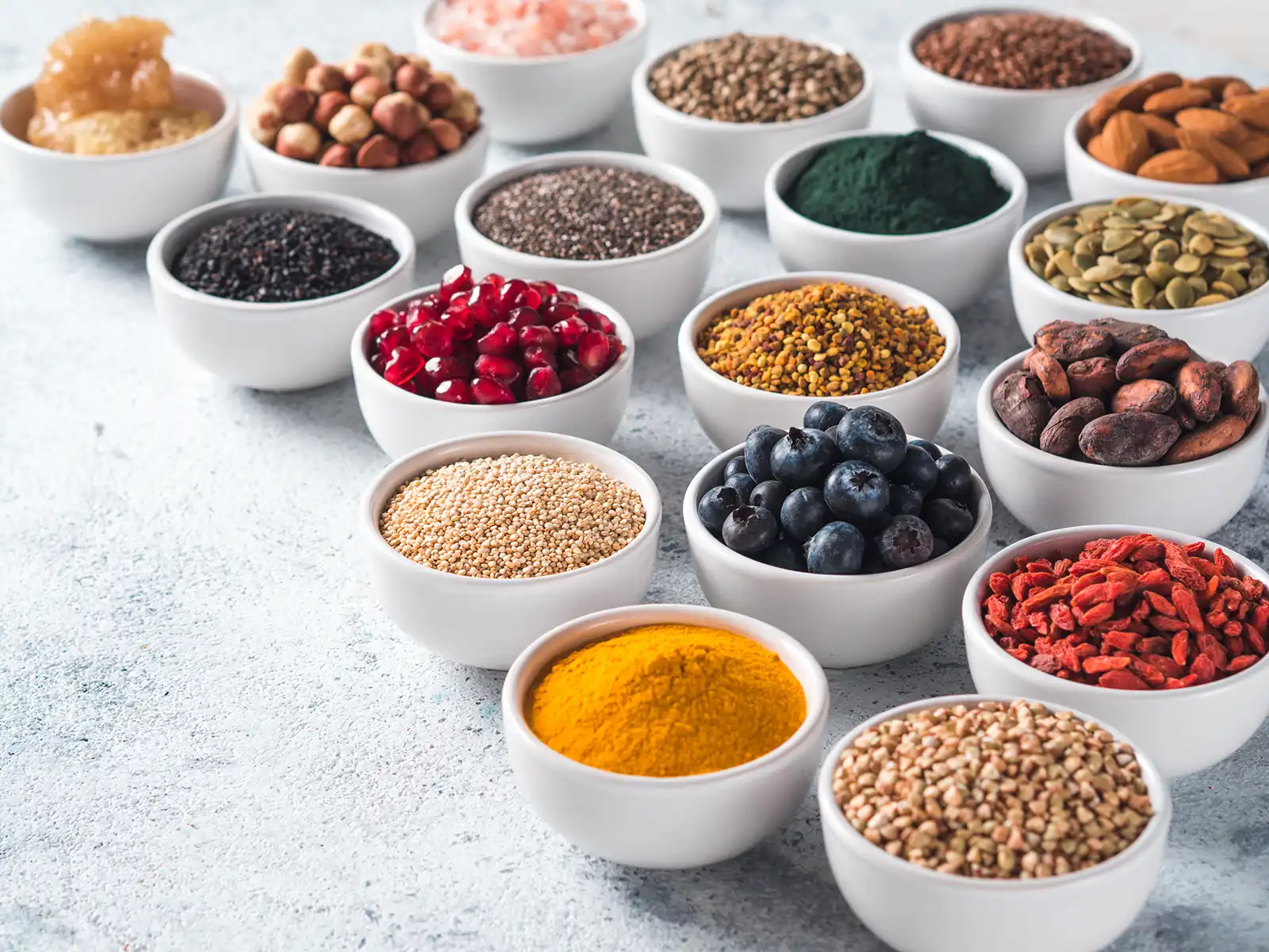Bowls of whole, natural ingredients: nuts, seeds, berries and spices