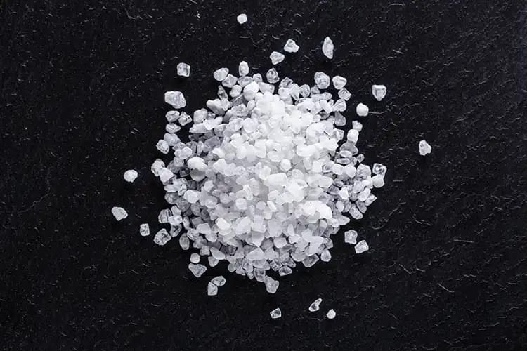 Coarse sea salt crystals on a dark surface